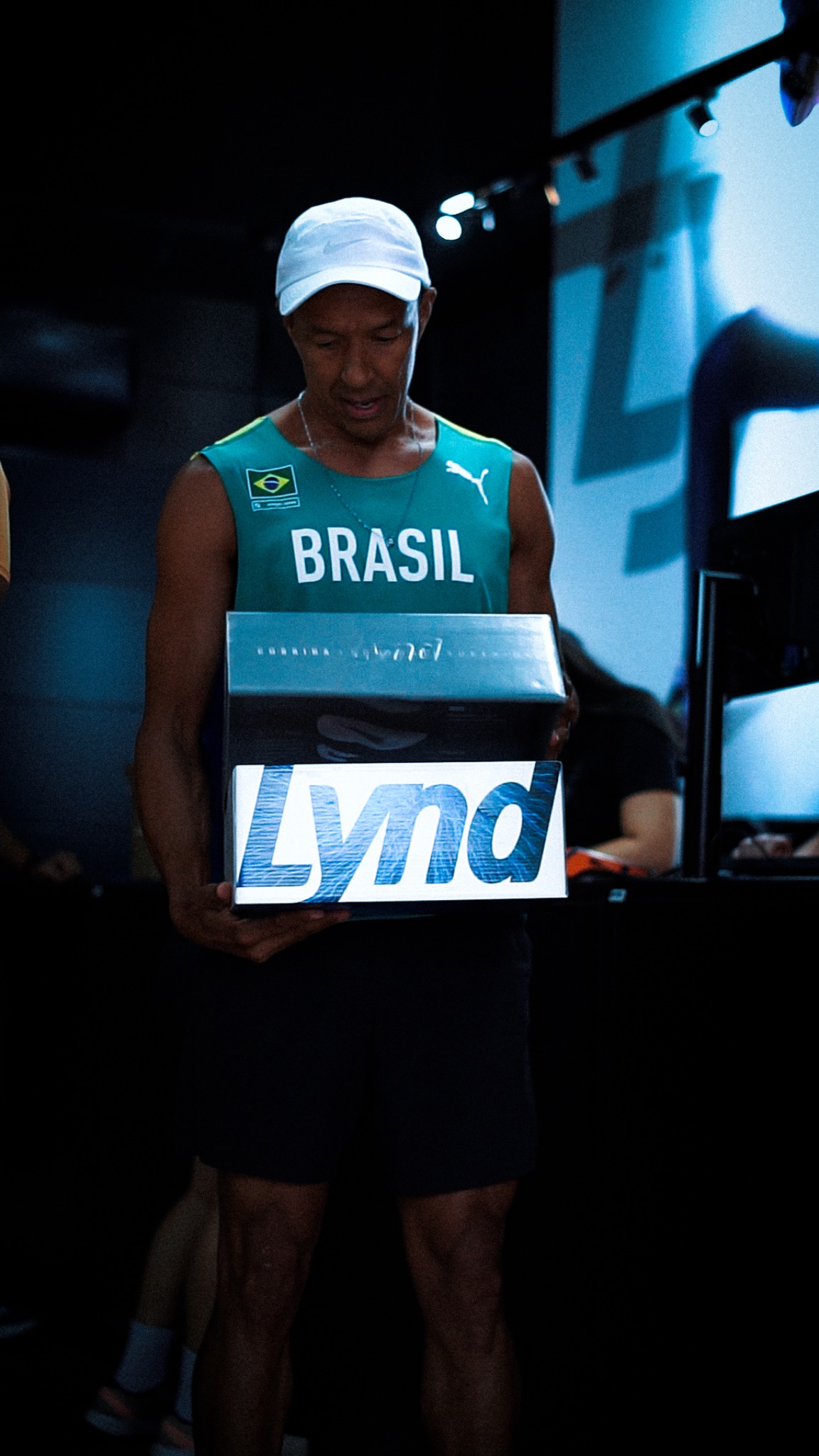 Atleta brasileiro segurando uma caixa de tênis Lynd